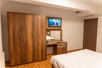 a bedroom with a bed and a desk with a television at Bici Resort in Samoljica