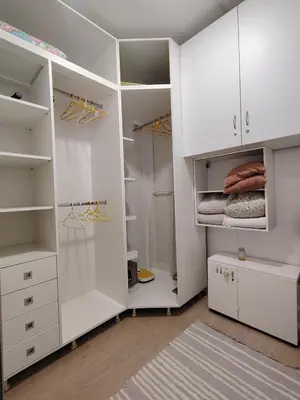a white walk in closet with white cabinets at SQUARE apartment in Ćuprija