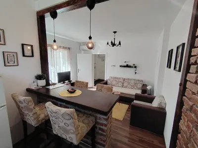a kitchen and living room with a table and chairs at SQUARE apartment in Ćuprija