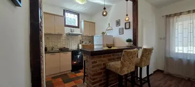 a kitchen with a counter and two chairs in it at SQUARE apartment in Ćuprija