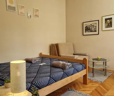 a bedroom with a bed and a chair and a table at Apartmani Central Vrnjačka Banja Šetalište in Vrnjačka Banja