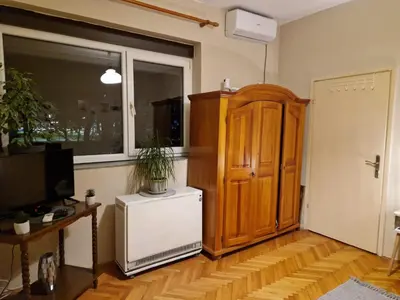 a living room with a television and a wooden cabinet at Apartmani Central Vrnjačka Banja Šetalište in Vrnjačka Banja
