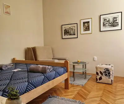 a bedroom with a bed and a chair and a table at Apartmani Central Vrnjačka Banja Šetalište in Vrnjačka Banja