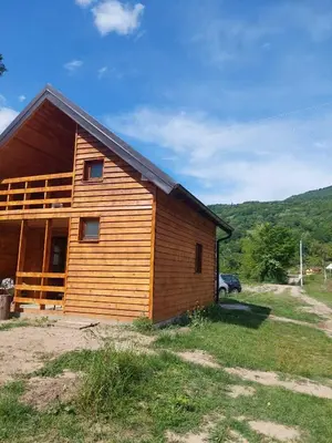 a wooden cabin with a car parked next to it at Drinska Ljepotica Ljubovija in Bukorovac