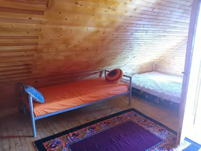 a small bed in a room with wooden walls at Drinska Ljepotica Ljubovija in Bukorovac