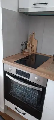 a kitchen with an oven with a wooden counter top at Planet-A1012 in Niš