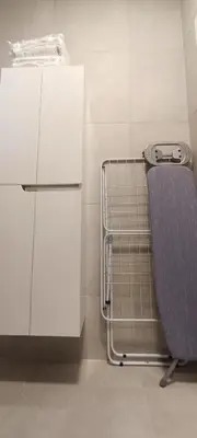a bathroom with a chair and a white refrigerator at Planet-A1012 in Niš