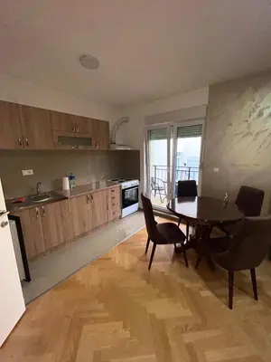 a kitchen with a table and chairs and a dining room at Banjski Raj in Vrnjačka Banja