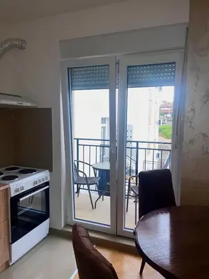 a kitchen with sliding doors to a balcony with a table at Banjski Raj in Vrnjačka Banja
