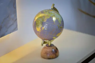 a small globe on a stand on a table at Amazon Royale Apartment in Niš