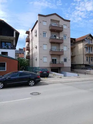 a black car parked in front of a building at Bufan apartman in Soko Banja