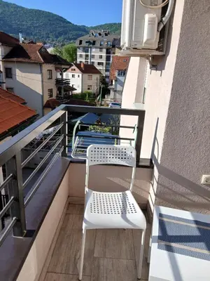 a white chair sitting on a balcony with a view at Bufan apartman in Soko Banja