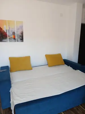a blue bed with two pillows on top of it at Bufan apartman in Soko Banja