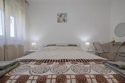 a large bed in a room with two chairs at Apartman Pepa in Pirot