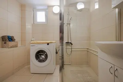 a bathroom with a washing machine and a sink at Apartman Pepa in Pirot