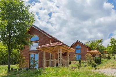 a wooden house with a gambrel roof at Etno selo Čubura in Čubura