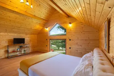a bedroom with a bed in a wooden room at Etno selo Čubura in Čubura