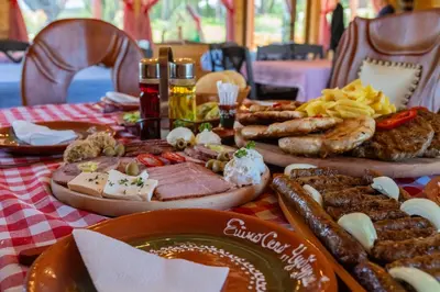 a table topped with different types of meats and cheese at Etno selo Čubura in Čubura