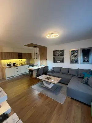 a living room with a blue couch and a table at Apartman Zelena laguna in Vrnjačka Banja