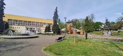 a building with a fountain in the middle of a park at Apartman Zelena laguna in Vrnjačka Banja