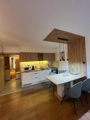 a kitchen with a table and a dining room at Apartman Zelena laguna in Vrnjačka Banja