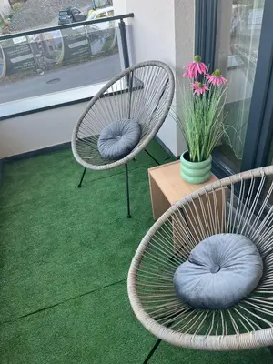 two chairs with blue pillows sitting on a green carpet at Apartman Zelena laguna in Vrnjačka Banja