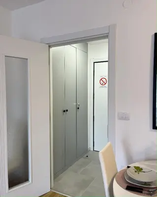 a room with a glass door with a table and a room with a no entry at Slatina Točak in Vrnjačka Banja
