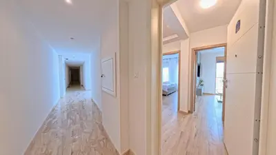 a hallway with white walls and a hard wood floor at Apartmani Central A50 & Free Parking in Vrnjci