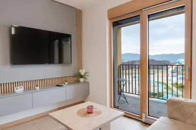 a living room with a tv and a balcony at Apartmani Central A50 & Free Parking in Vrnjci