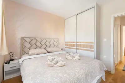 a bedroom with a bed with towels on it at Duma Apartmani 2 Vrnjačka Banja in Vrnjačka Banja