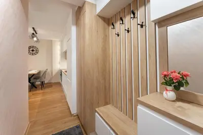 a hallway with wood paneling and a vase of flowers at Duma Apartmani 2 Vrnjačka Banja in Vrnjačka Banja