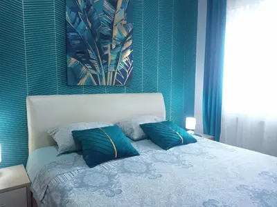 a bedroom with a bed with two blue pillows at Emilija Apartments in Soko Banja