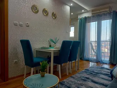 a dining room with a table and blue chairs at Emilija Apartments in Soko Banja
