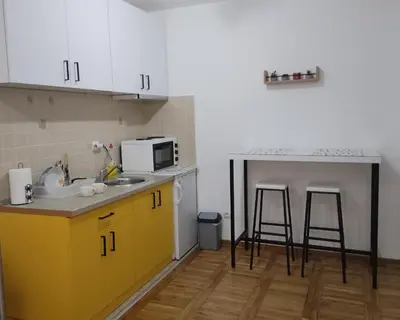 a kitchen with a sink and a counter with stools at Apartman Sunshine in Vrnjačka Banja
