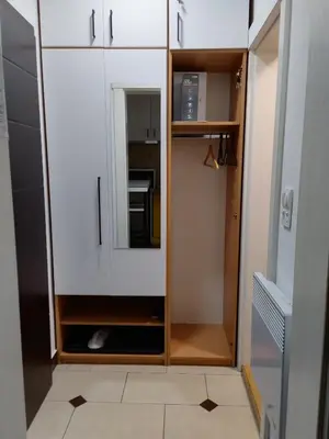 a closet with white cabinets and a mirror at Apartman Sunshine in Vrnjačka Banja