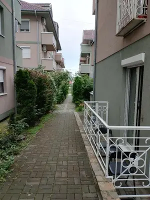an alley way between two buildings with a balcony at Apartman Sunshine in Vrnjačka Banja