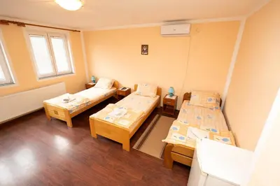 a room with two beds and two tables at Sobe Joksimović in Vrnjačka Banja
