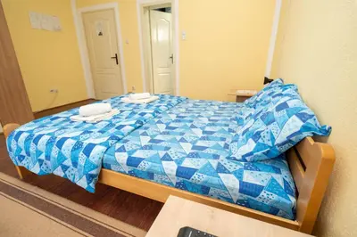 a bedroom with a blue and white bed with a mirror at Sobe Joksimović in Vrnjačka Banja