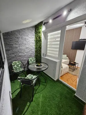 a room with a table and chairs and a plant at Apartman Tara in Soko Banja
