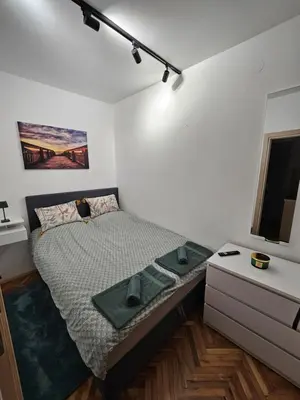 a small bedroom with a bed and a dresser at Apartman Tara in Soko Banja