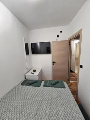 a bedroom with a bed with two green pillows at Apartman Tara in Soko Banja