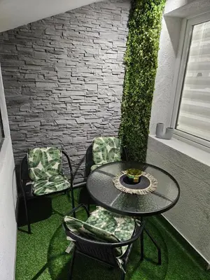 a patio with a table and chairs and a brick wall at Apartman Tara in Soko Banja