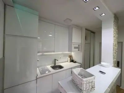 a white kitchen with a sink and a counter at LUCHIANO apartments in Niš