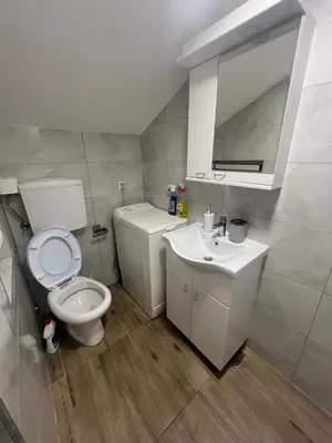a bathroom with a white toilet and a sink at S&M apartman FREE PARKING in Vranje
