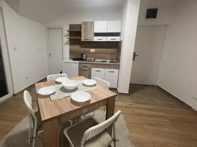 a kitchen with a table and chairs in a room at S&M apartman FREE PARKING in Vranje