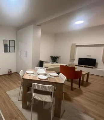 a living room with a table and chairs and a bed at S&M apartman FREE PARKING in Vranje