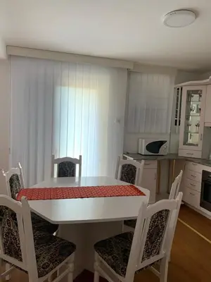 a kitchen with a white table and chairs and a table and chairsktop at SAN 1 apartman in Soko Banja