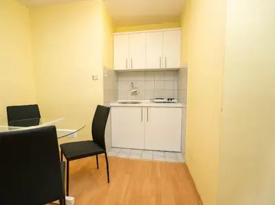 a kitchen with a table and a table and chairs at Apartmani Votor in Vrnjačka Banja