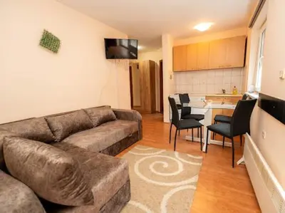 a living room with a couch and chairs and a kitchen at Apartmani Votor in Vrnjačka Banja