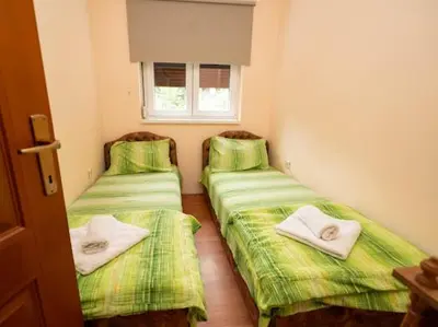 two beds in a room with green sheets and towels at Apartmani Votor in Vrnjačka Banja